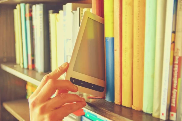 una persona tire fuori uno smartphone da uno scaffale per i libri