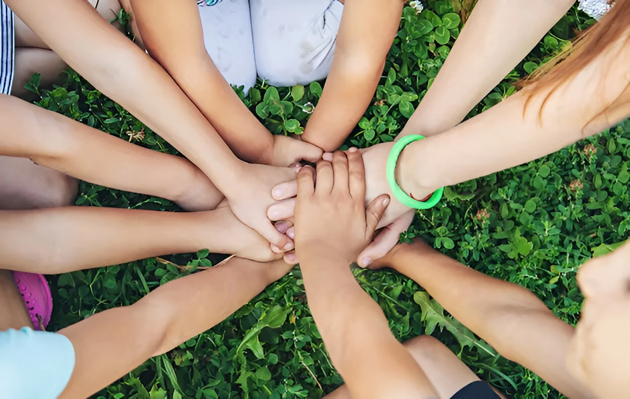 Un gruppo di bambini che uniscono le mani insieme